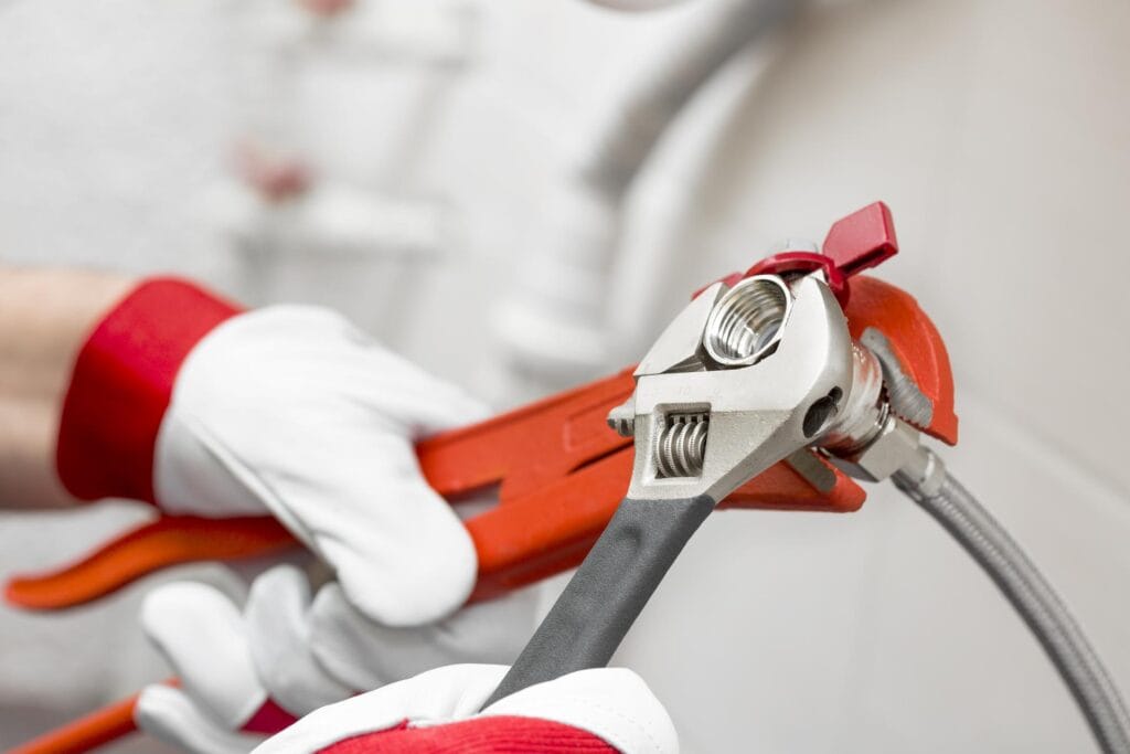 Plumber holding pipe wrenches for an emergency repair in Waco