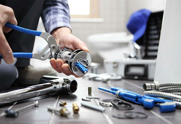 Technician repairing a plumbing fixture with professional tools in Waco