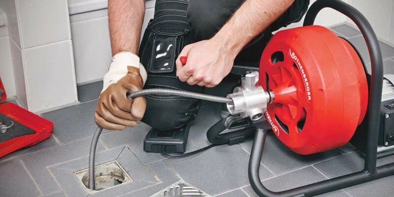 Plumber using a drain-cleaning machine in Waco