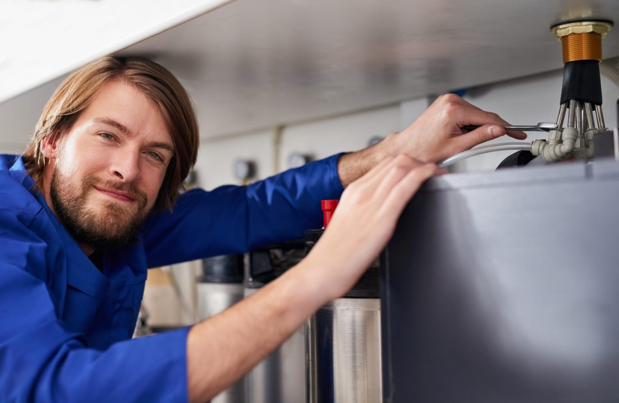 Technician servicing a residential water heater tank in Waco