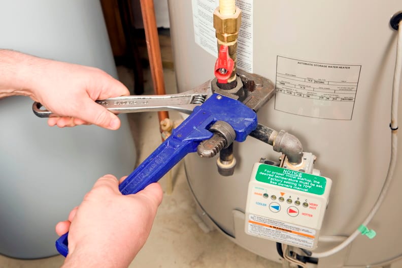 Plumber repairing a water heater valve in Waco